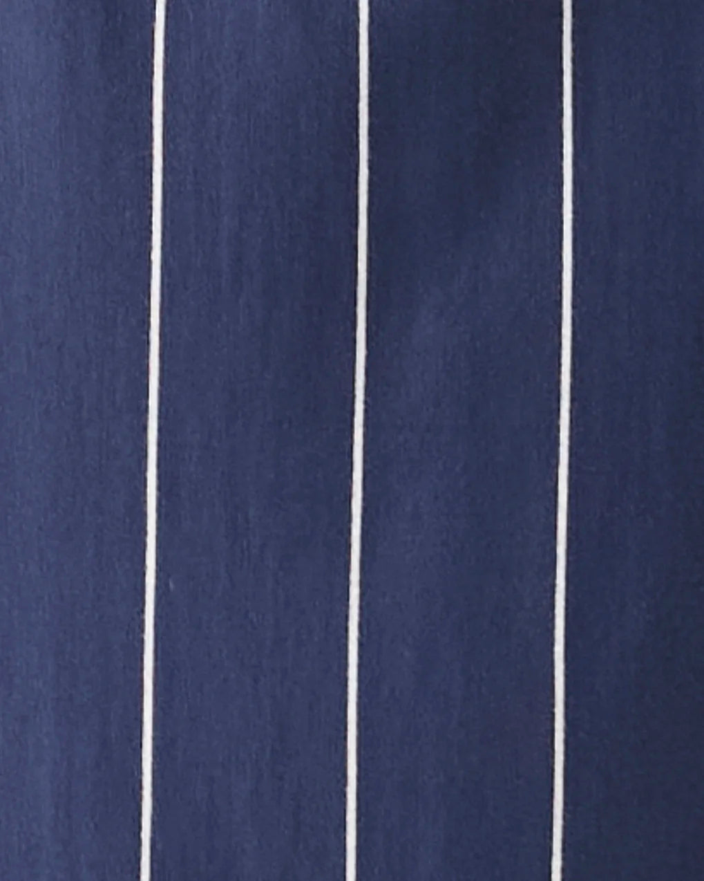 A close-up of navy blue fabric with thin vertical white pinstripes.