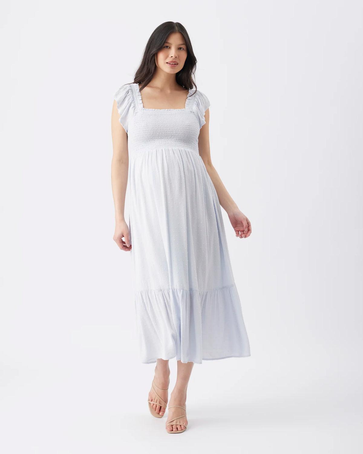 A woman modeling a white midi dress with puff sleeves, a square neckline, and a tiered skirt, photographed against a seamless white studio background.