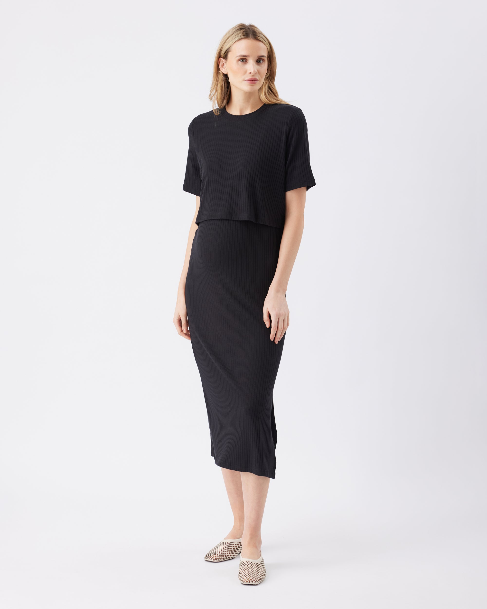 Woman wearing a black midi dress on a white background