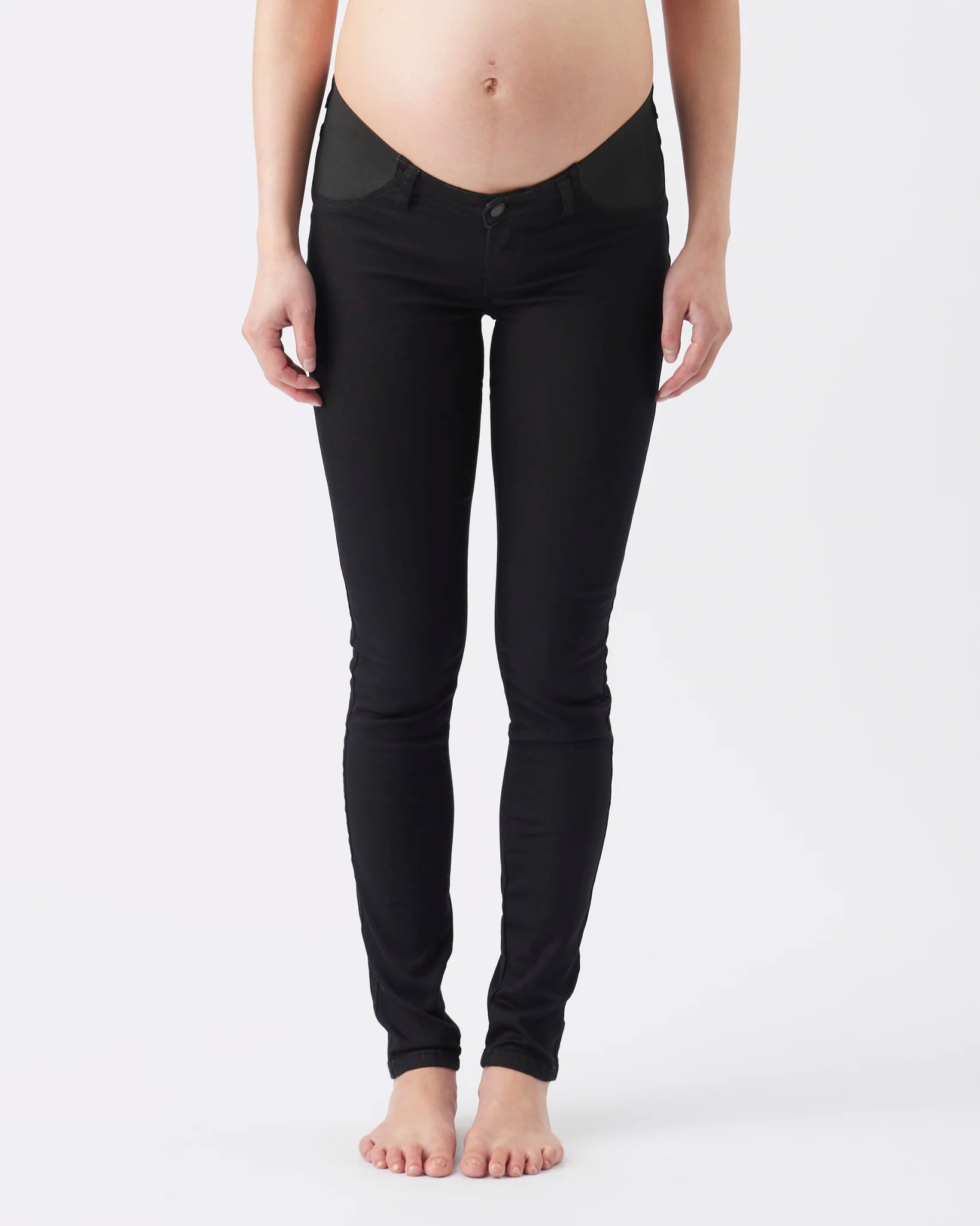 Black maternity leggings worn by a pregnant model, shown from the waist down against a plain white studio background.