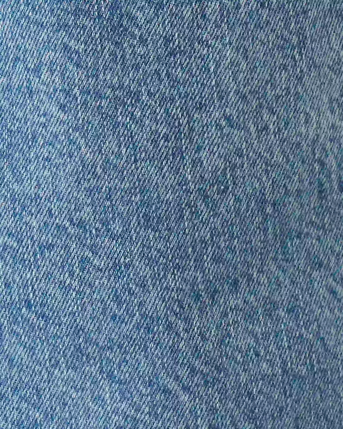 A close-up texture shot of blue denim fabric showing the woven twill pattern.