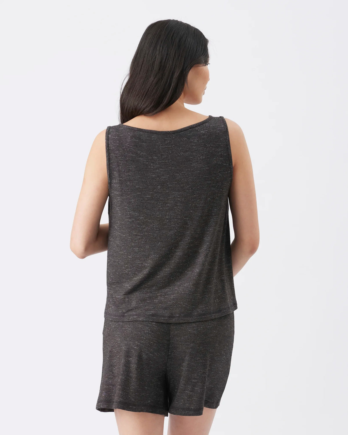 A woman shown from the back wearing a dark heather gray sleeveless top and matching shorts against a plain light gray studio background.