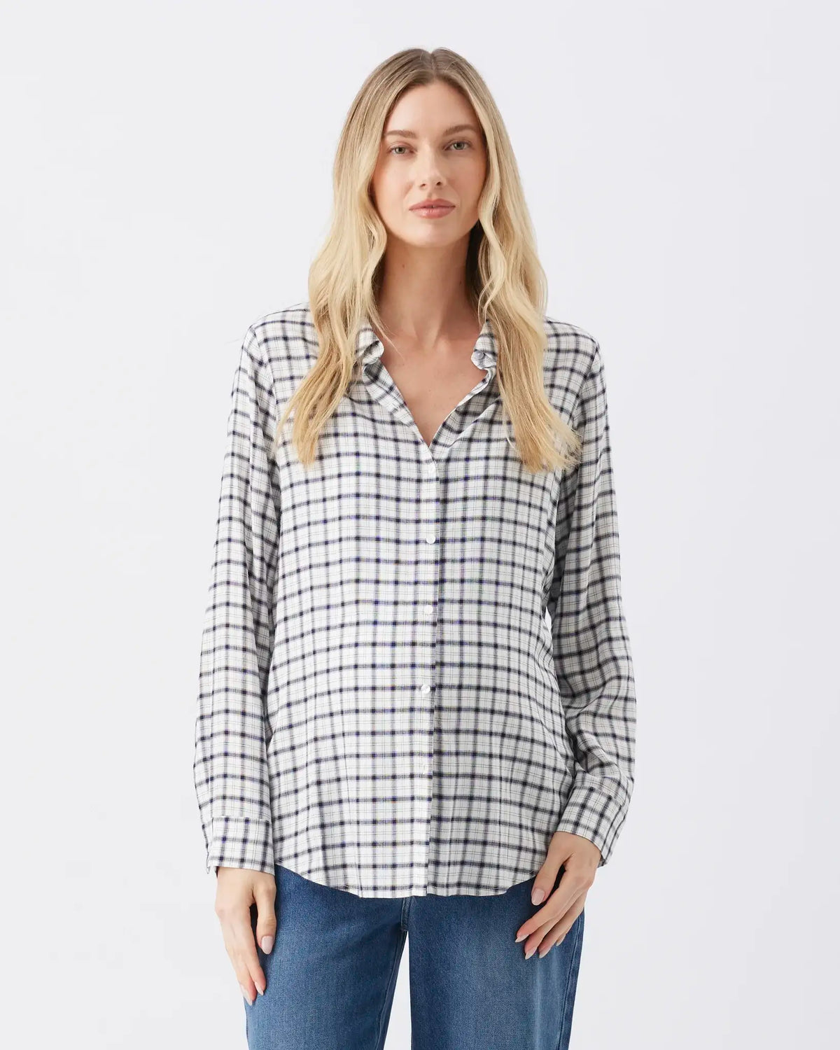 A woman modeling a black and white checkered long-sleeve button-up shirt with blue jeans, shot against a plain white studio background.