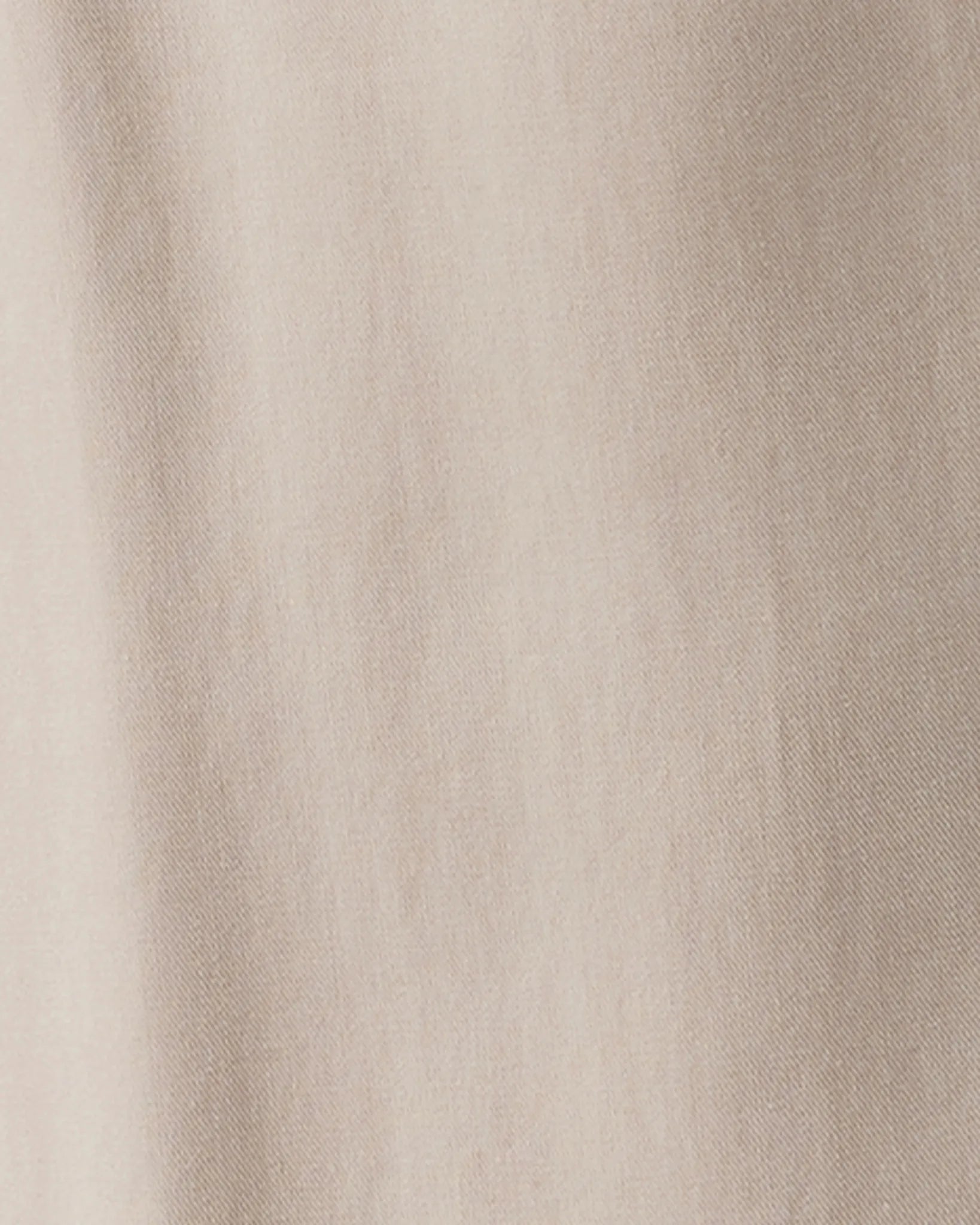 A close-up of a light beige fabric texture with soft vertical folds.