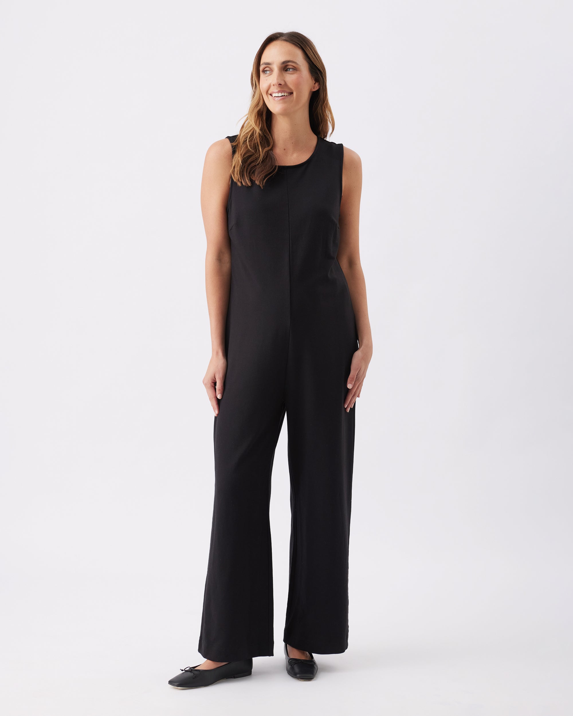 Pregnant woman wearing a black sleeveless full length jumpsuit from Ripe Maternity.