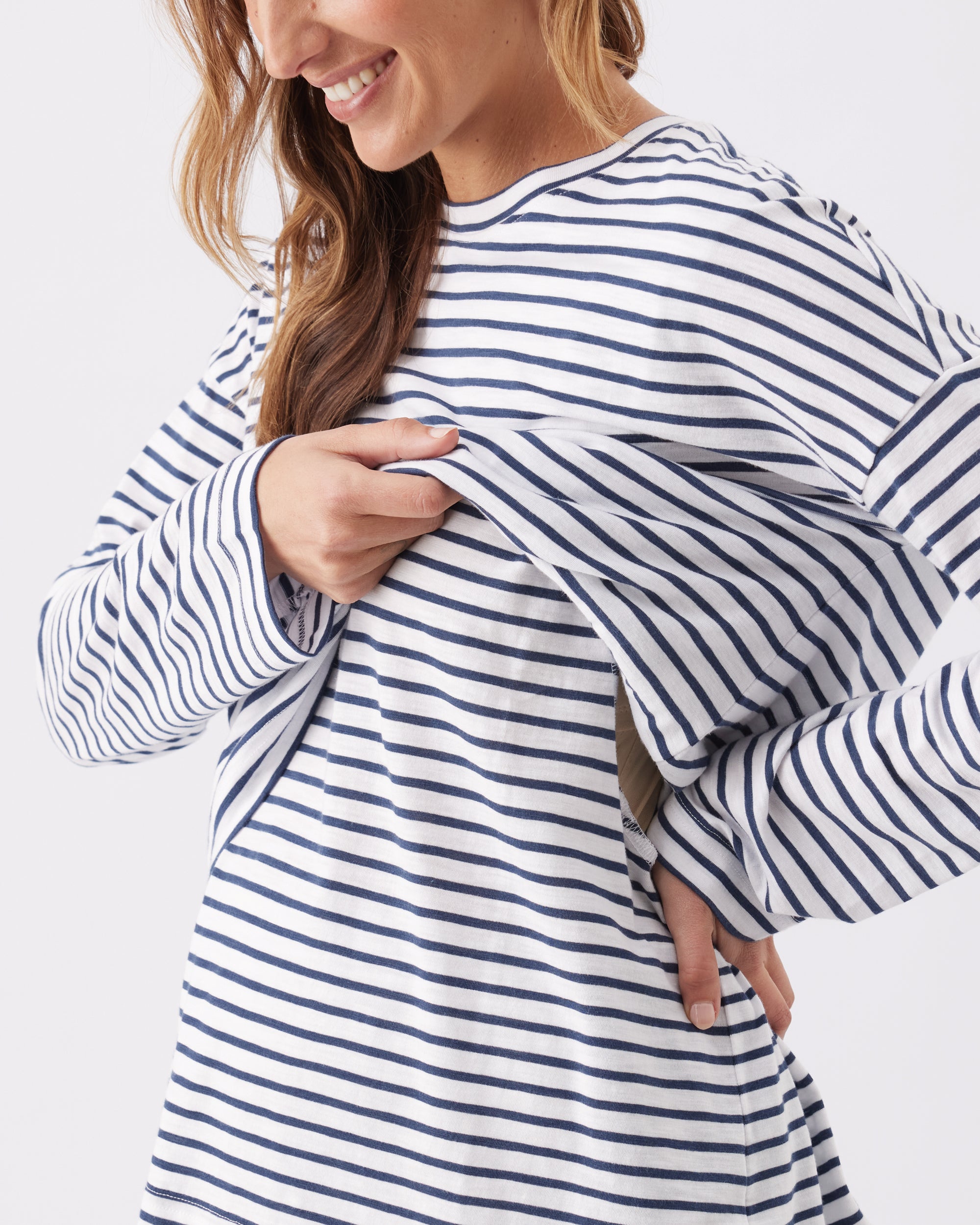 Woman lifting up the top of the Claudette Nursing Long Sleeve Top to show the nursing access.