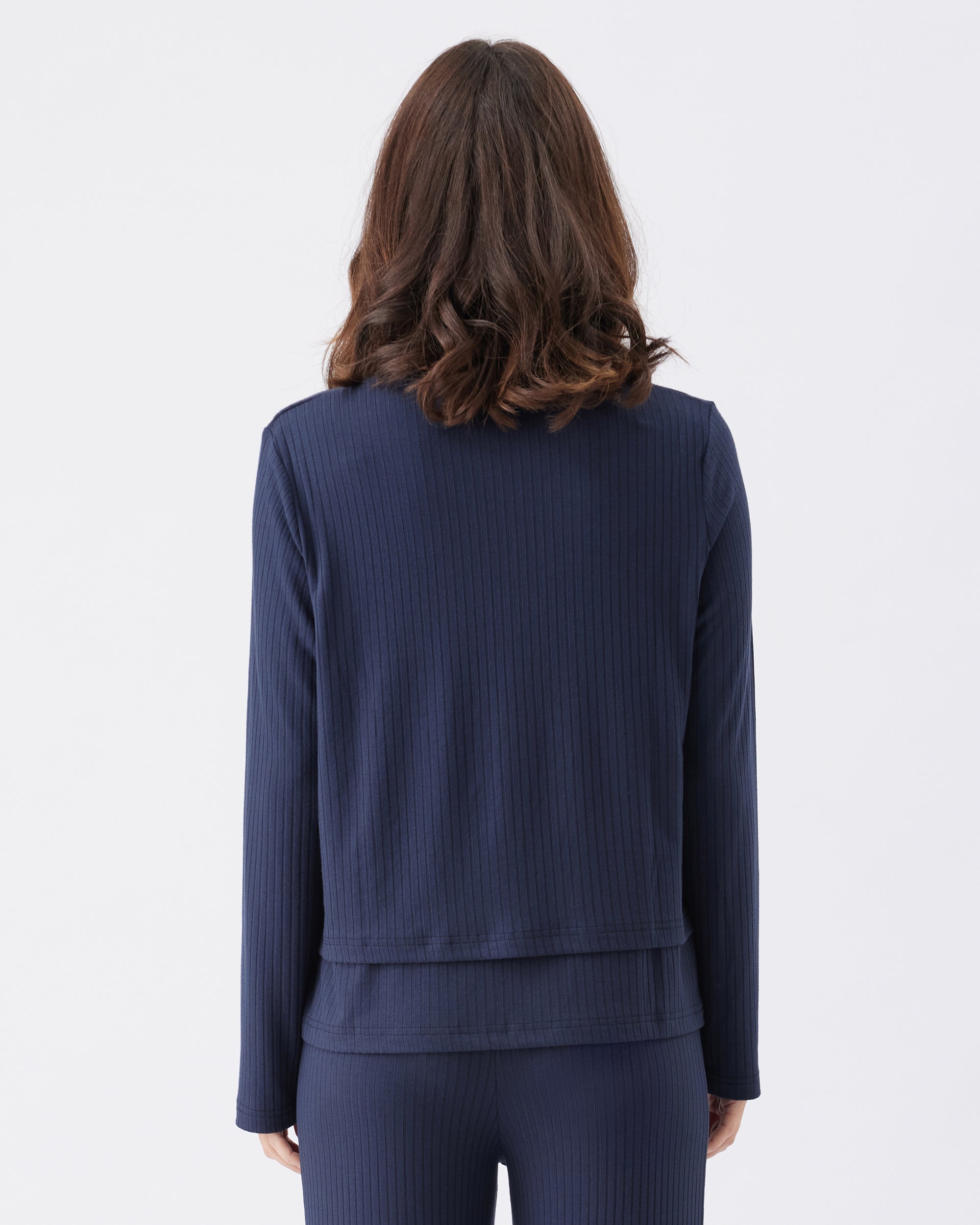 Back view of a woman wearing a navy blue outfit on a white background