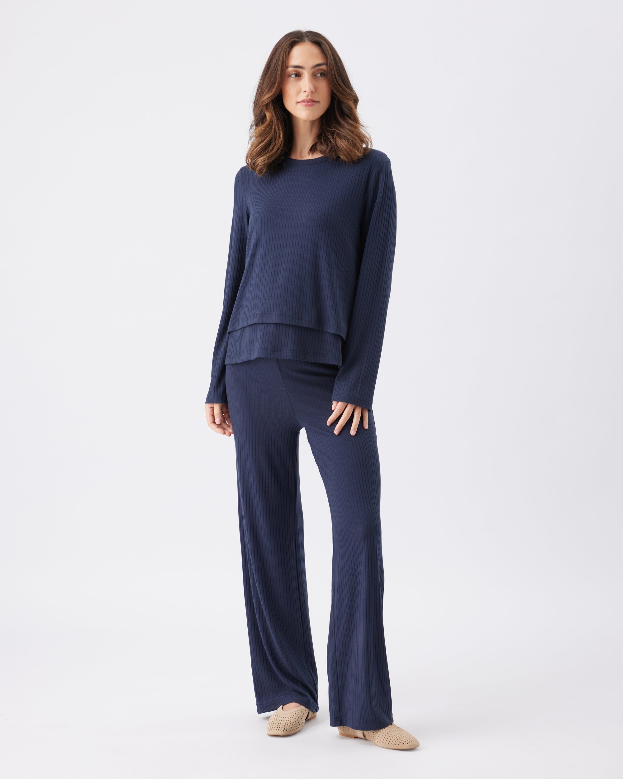Full lenght shot of a woman wearing a navy blue outfit on a white background