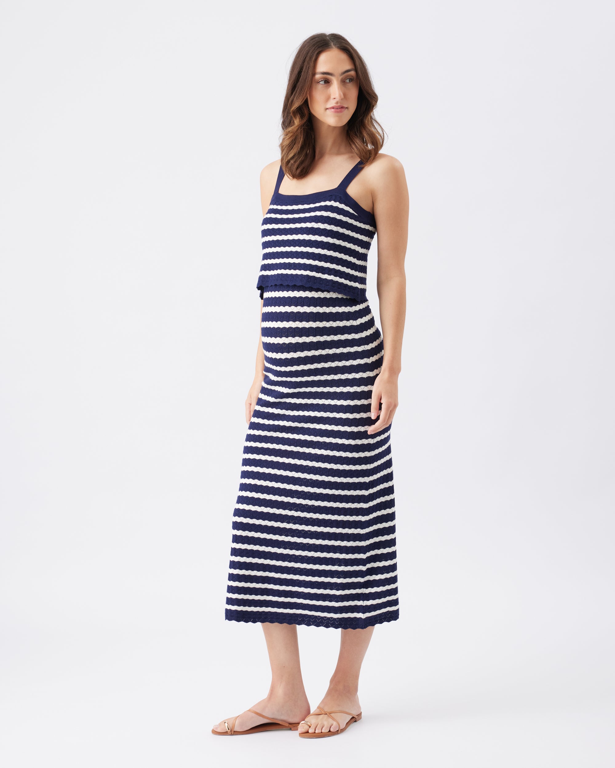 Woman wearing a navy and white striped dress on a white background