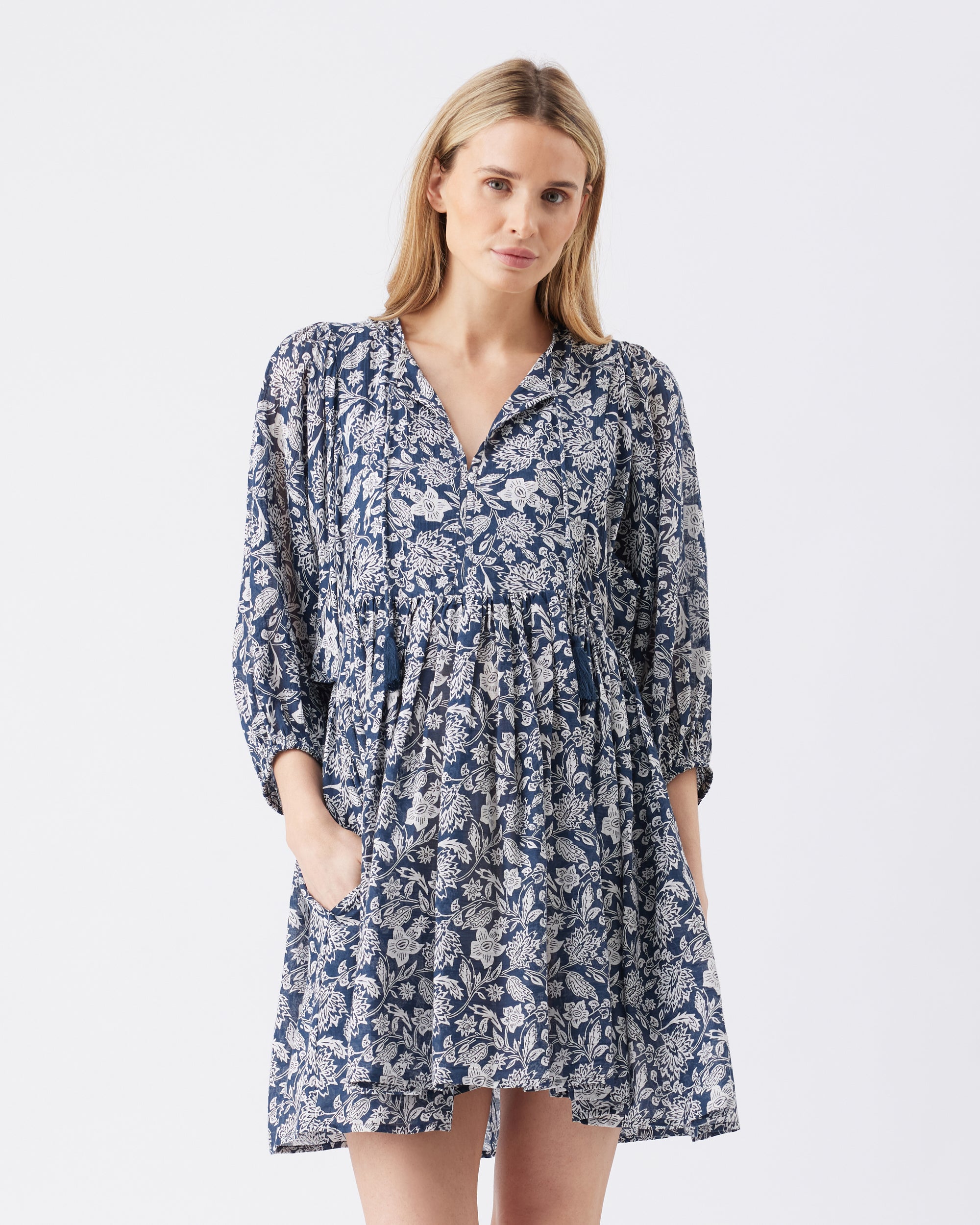 Woman wearing a blue floral mini dress on a white background