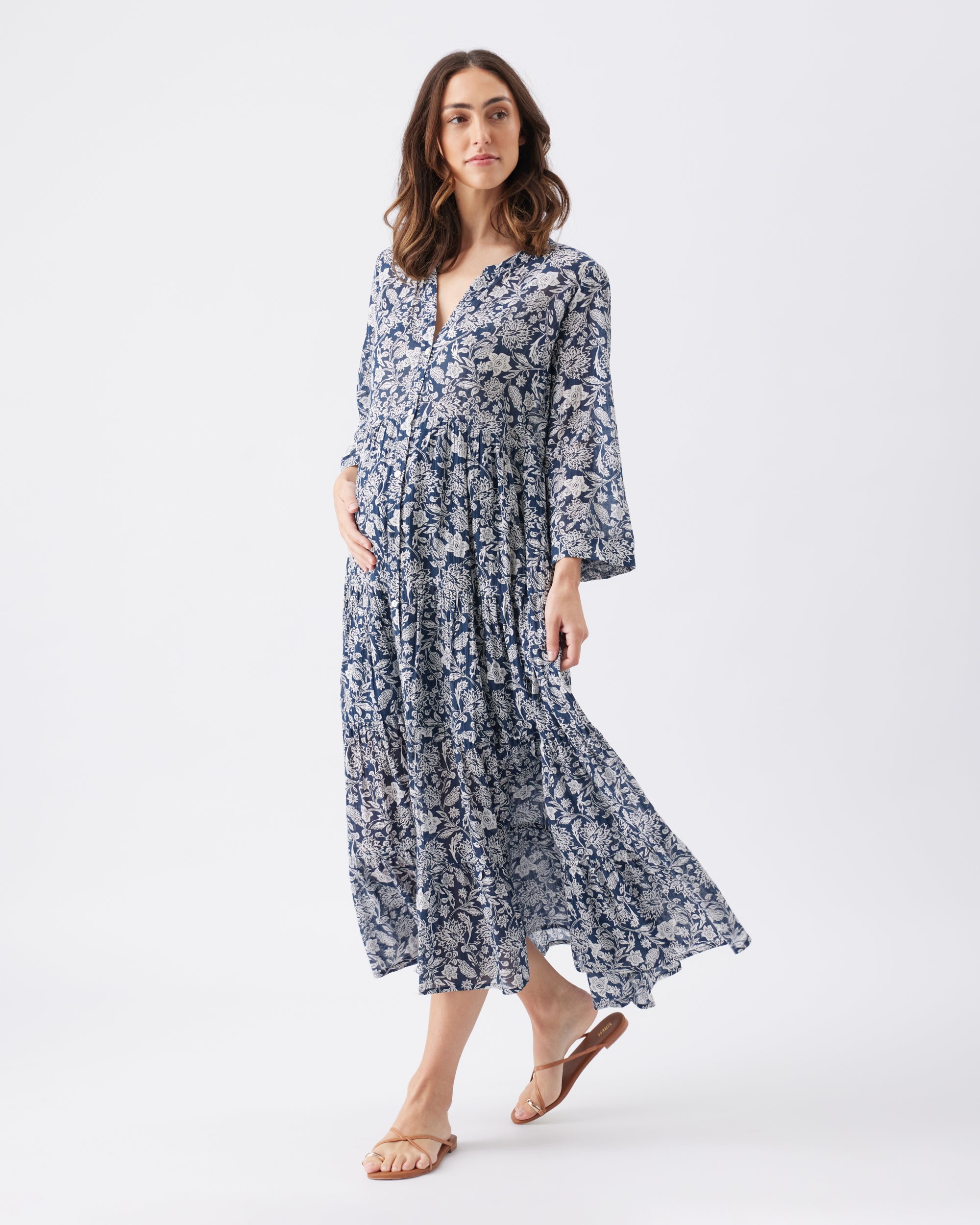 Woman wearing a blue floral summer dress on a white background