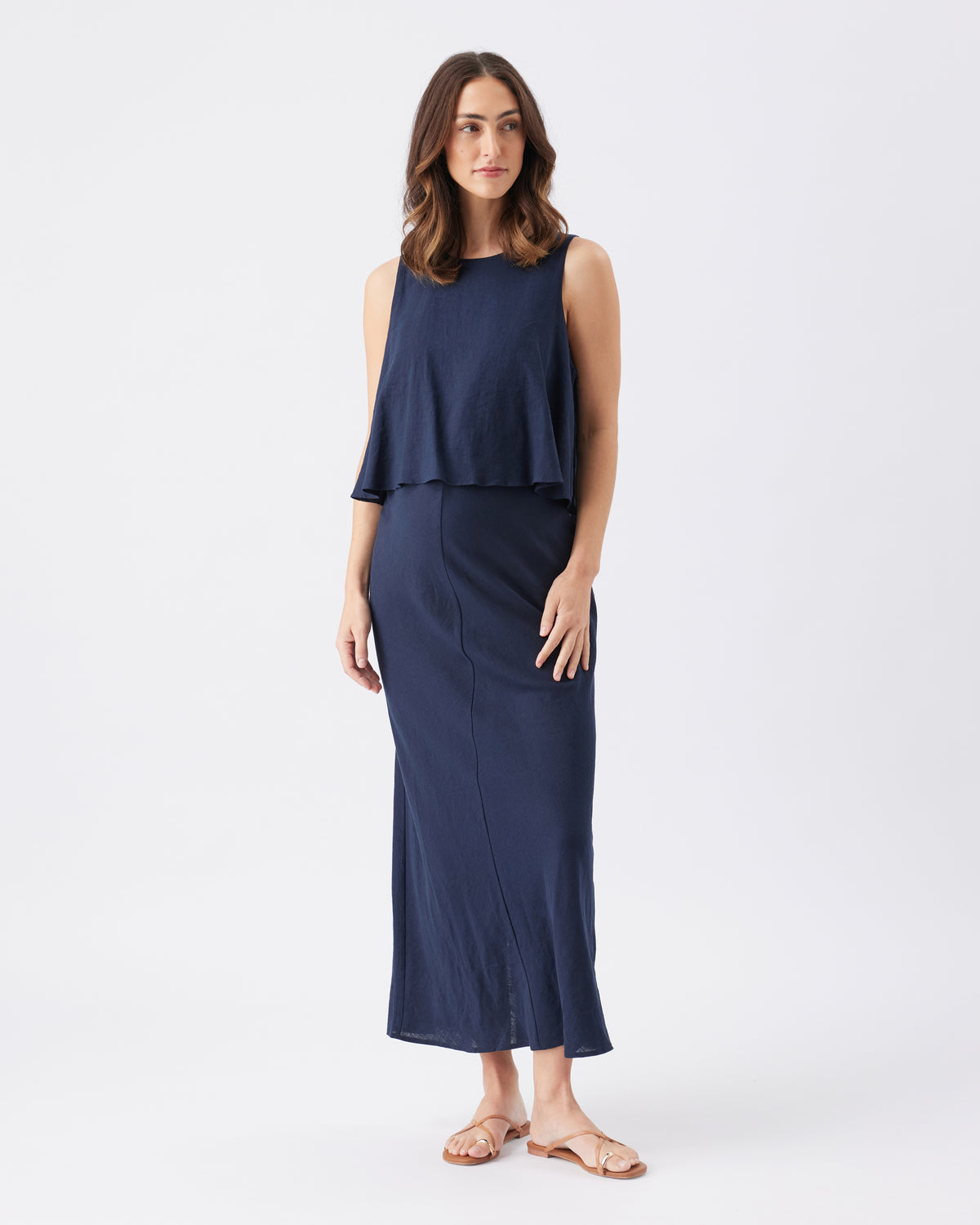 Woman wearing a navy blue layered dress on a white background