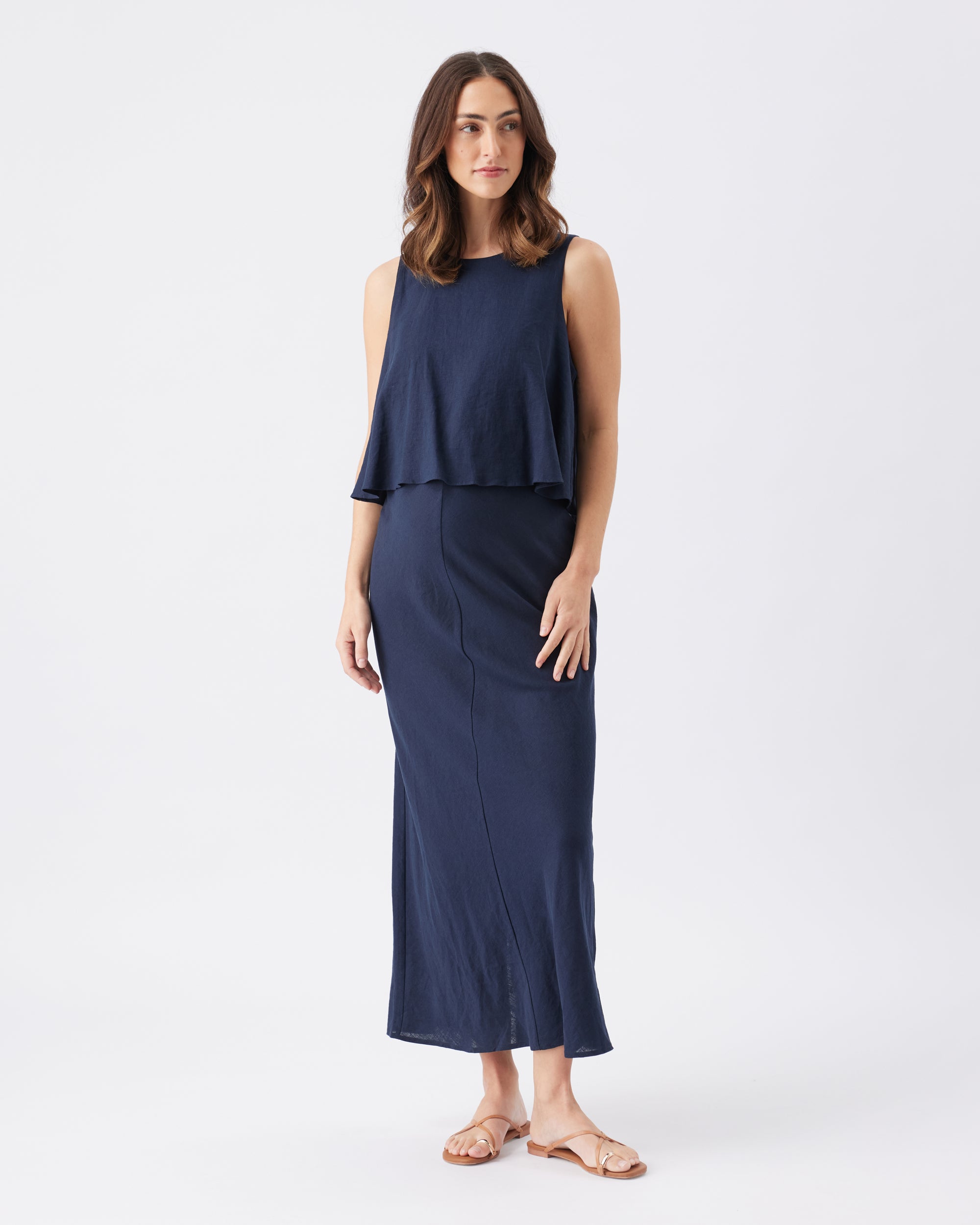 Woman wearing a navy blue layered dress on a white background