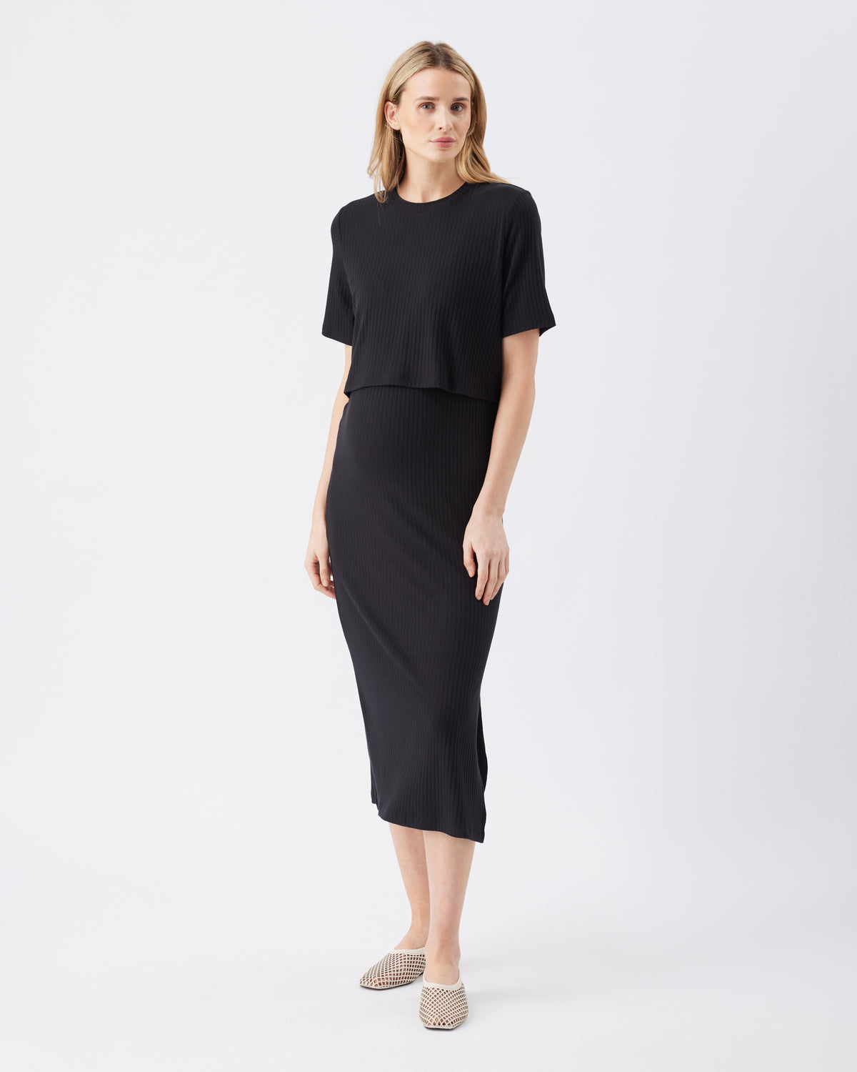 Woman wearing a black midi dress on a white background