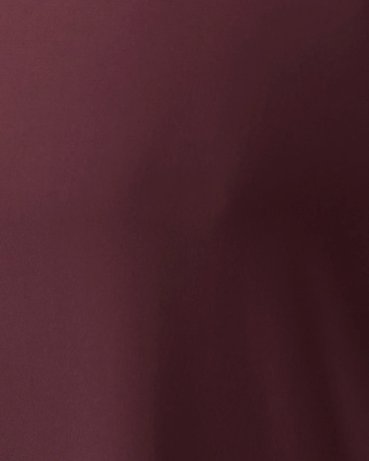 A close-up of a solid dark plum or burgundy fabric texture.