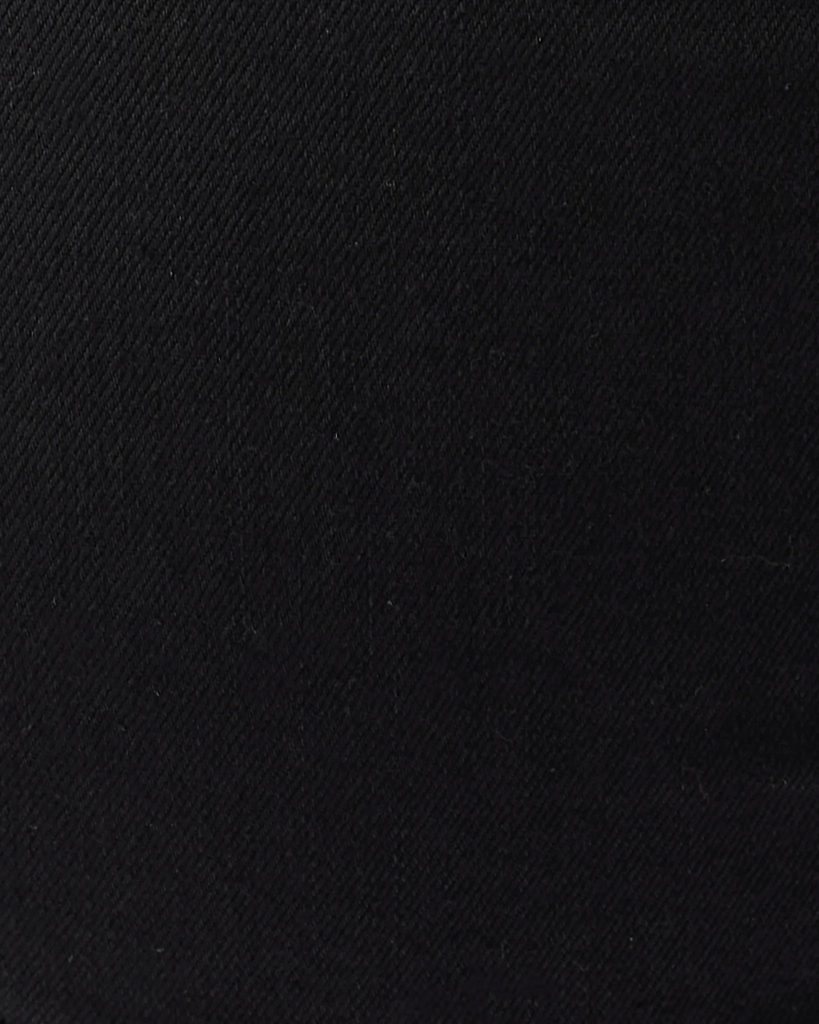 A close-up of a black textured fabric, showing a fine diagonal twill weave.