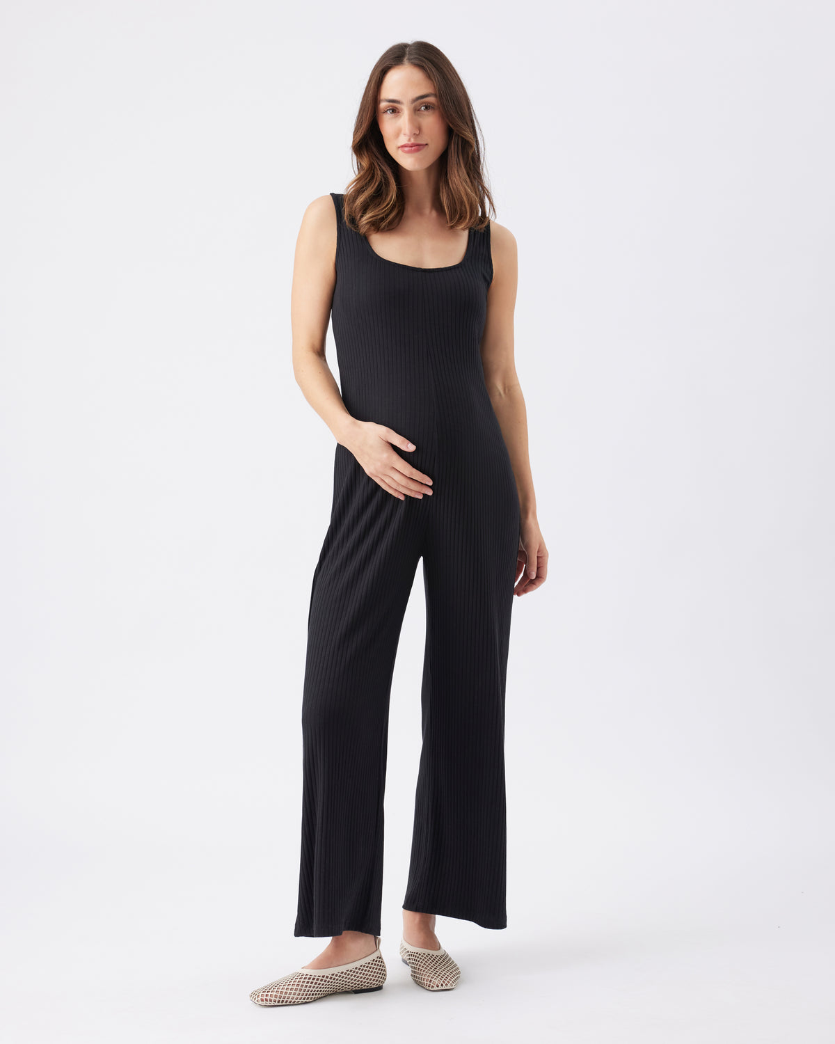 Woman wearing a black sleeveless jumpsuit on a white background