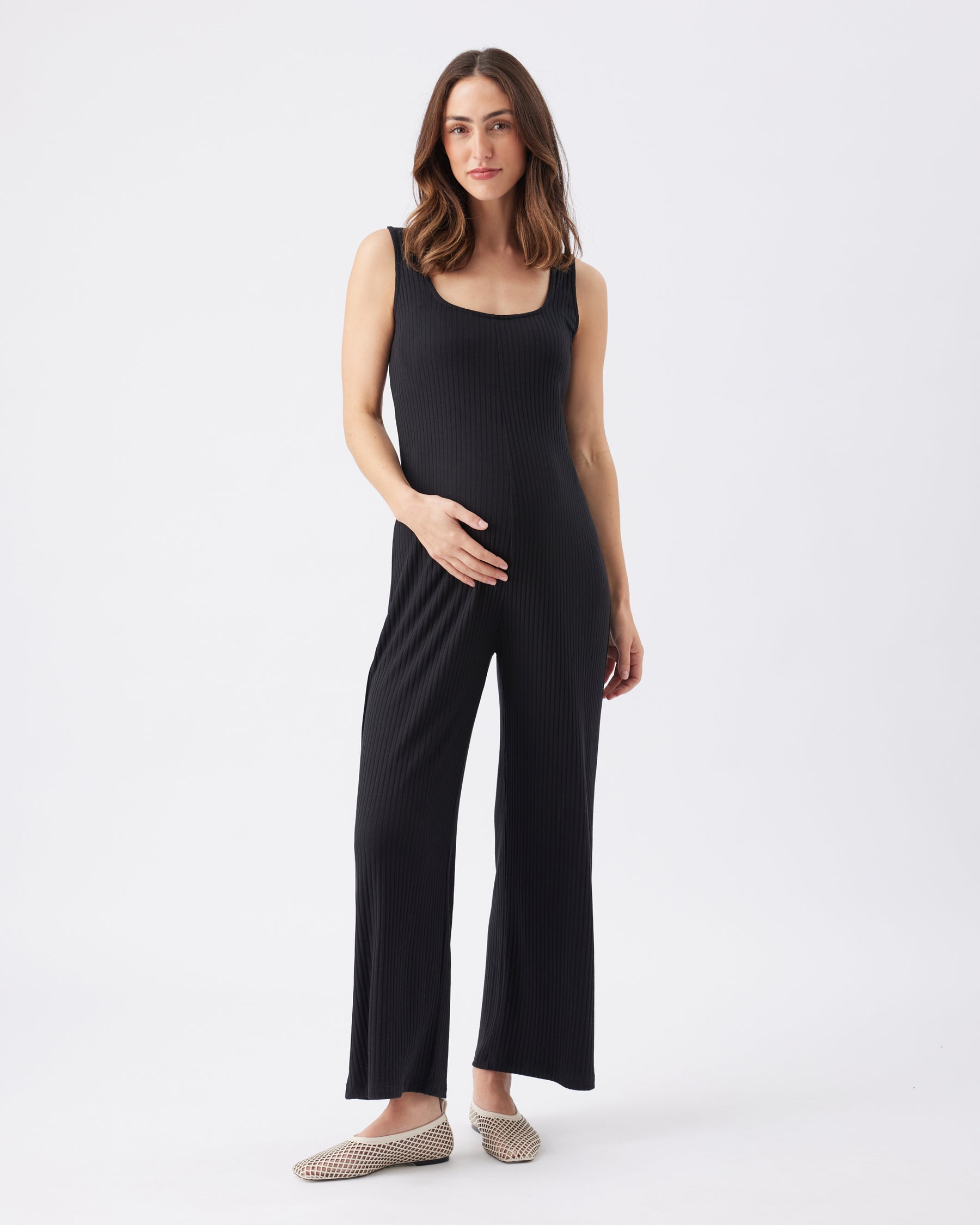 Woman wearing a black sleeveless jumpsuit on a white background