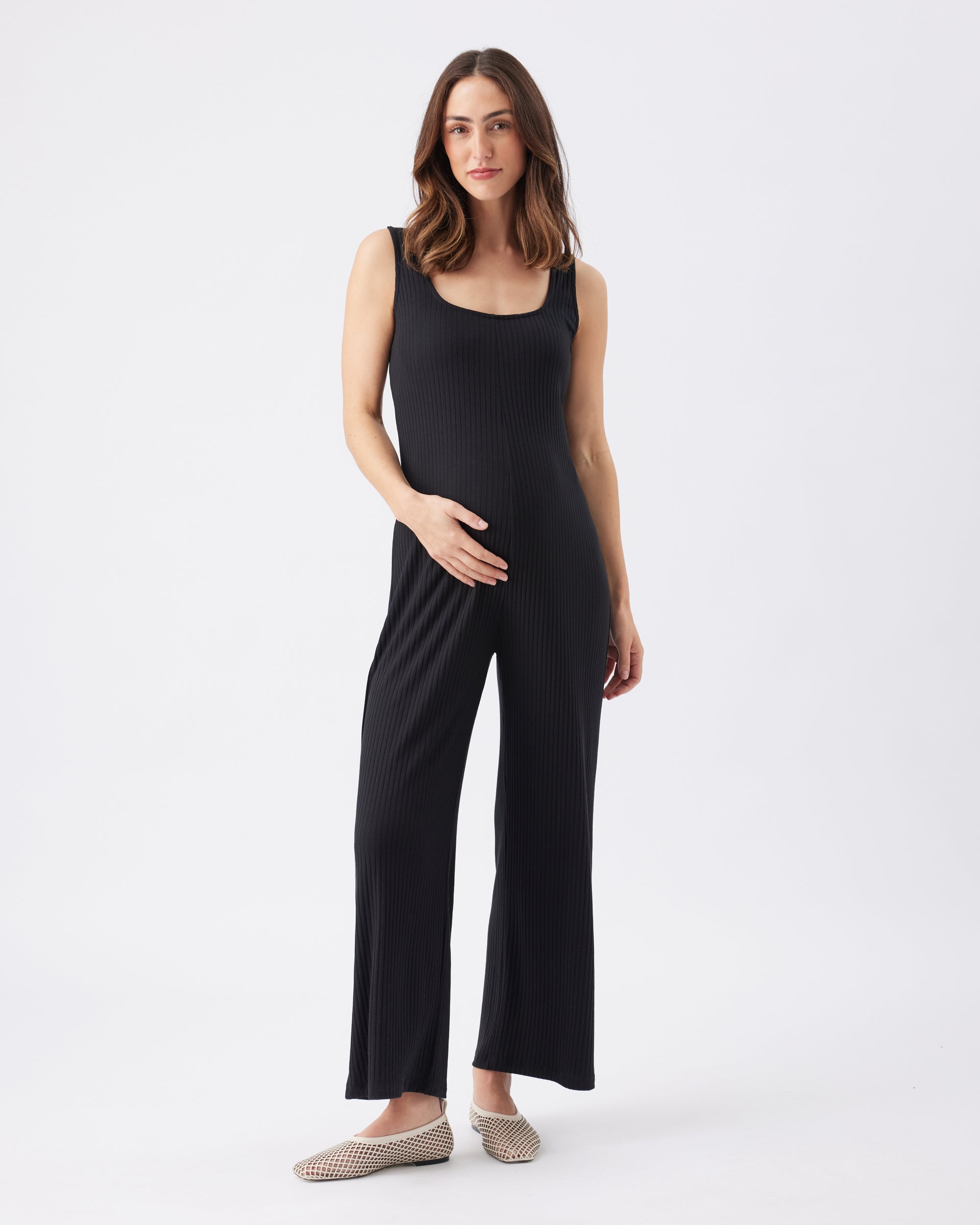 Woman wearing a black sleeveless jumpsuit on a white background