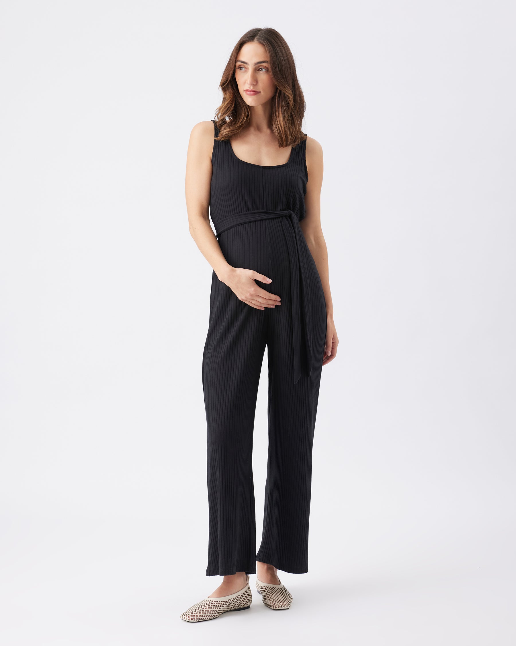 Woman wearing a black sleeveless jumpsuit on a white background