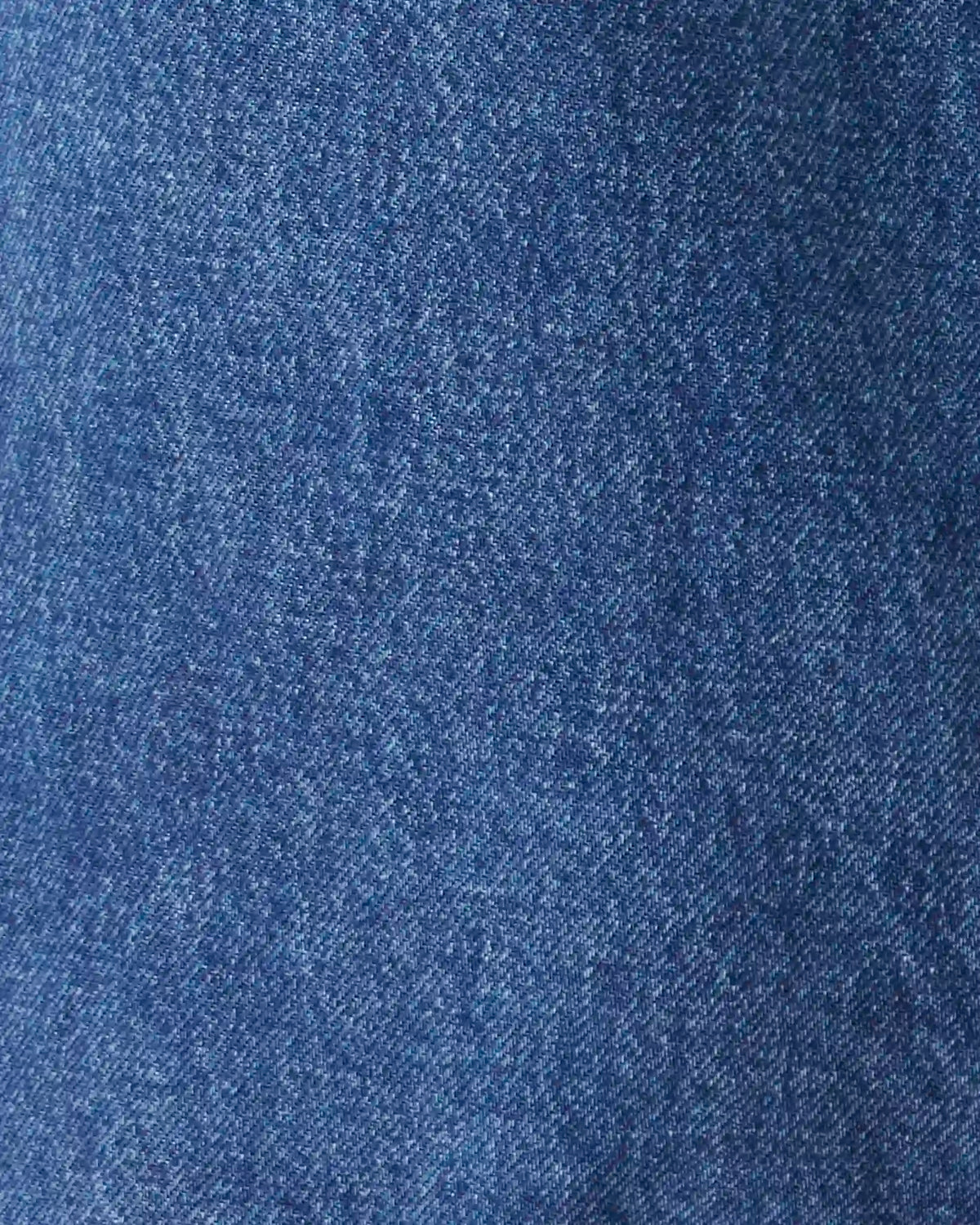 A close-up texture shot of medium blue denim fabric.