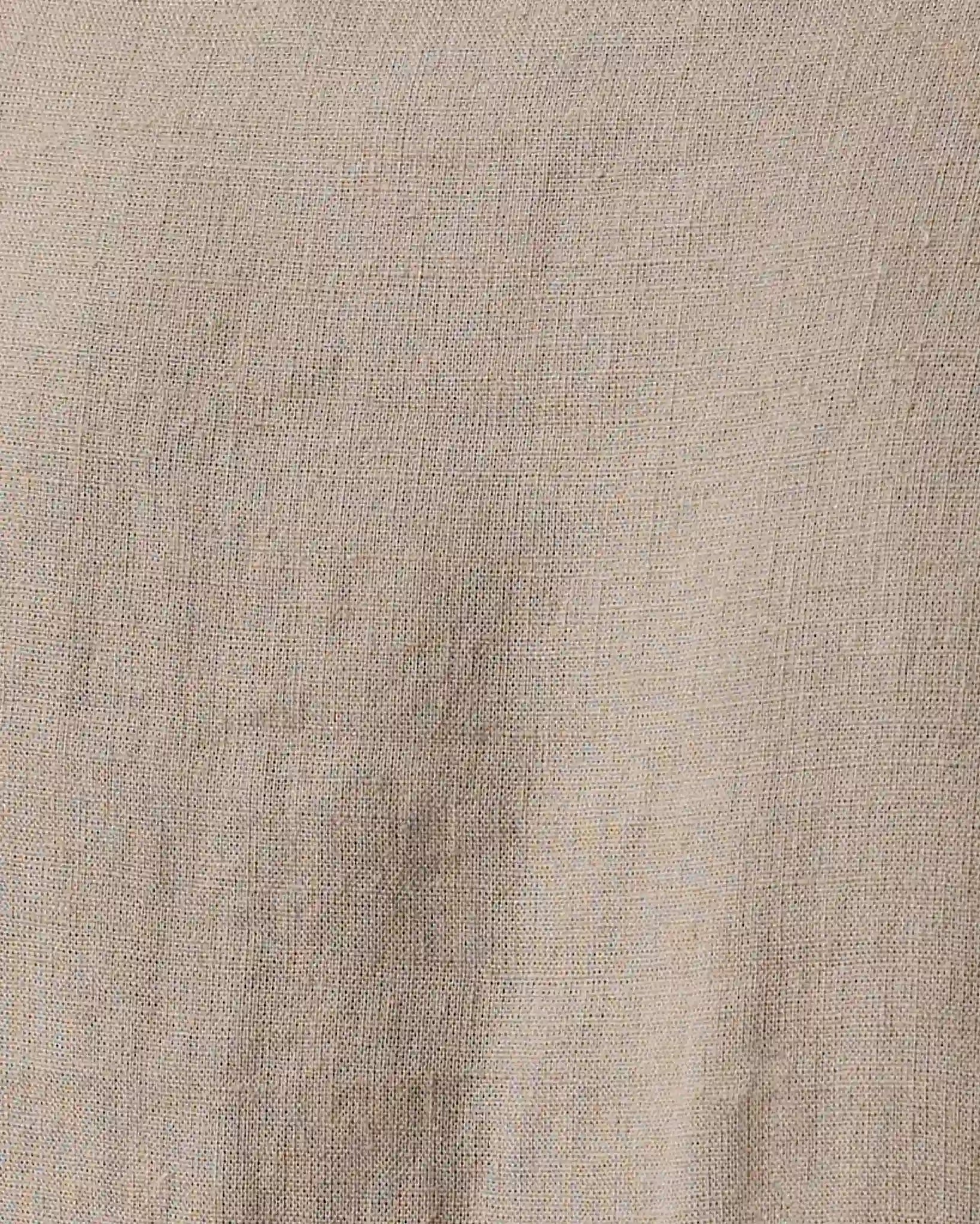 A close-up of a textured linen fabric in a light beige color, showing the woven weave and subtle natural folds.