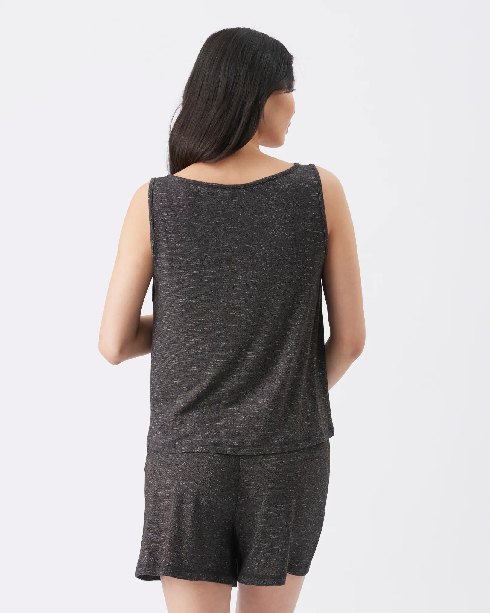 A woman shown from the back wearing a dark heather gray sleeveless top and matching shorts against a plain light gray studio background.