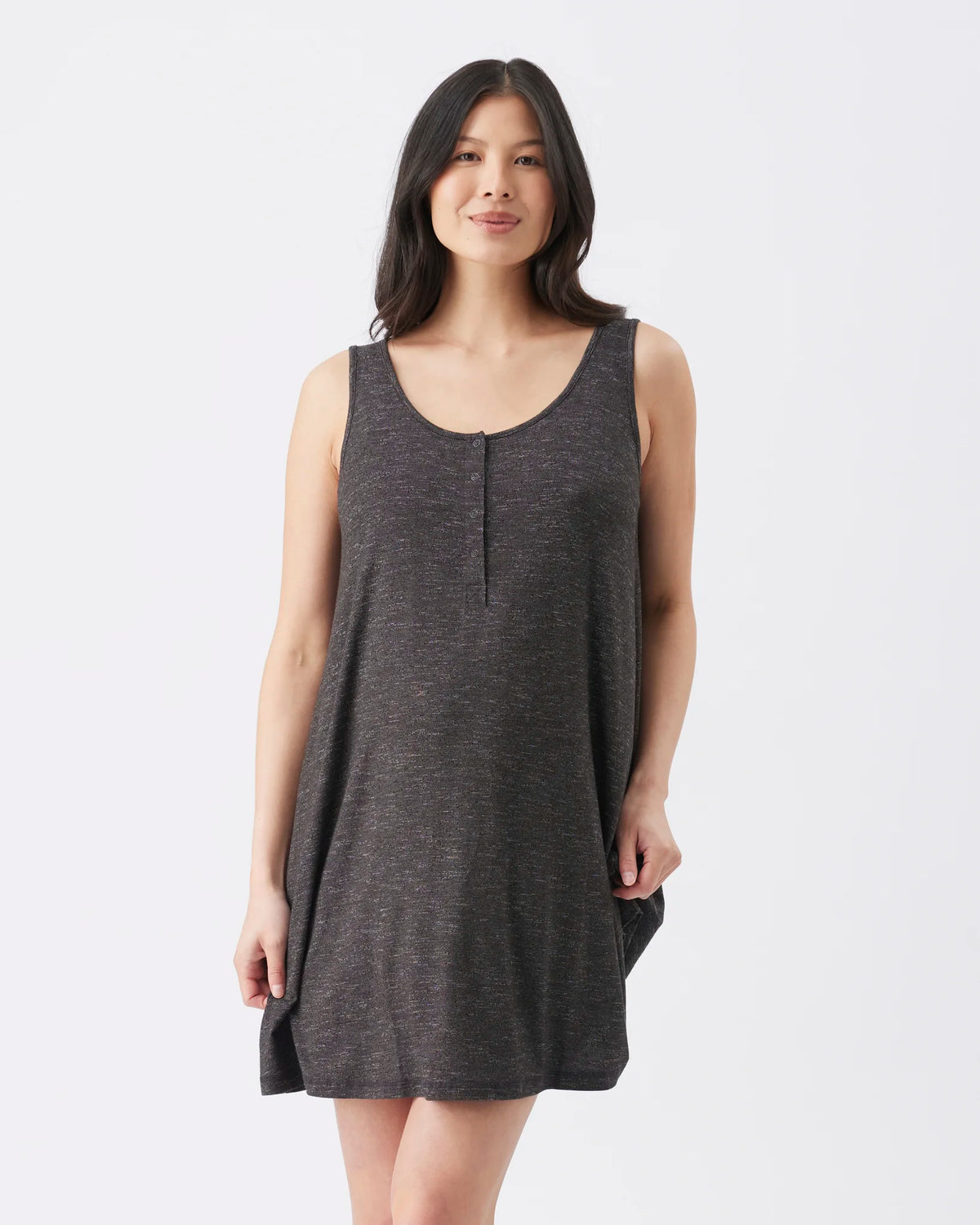 A woman modeling a dark gray sleeveless knit dress with a scoop neckline and a small center front slit, photographed against a plain light gray studio background.