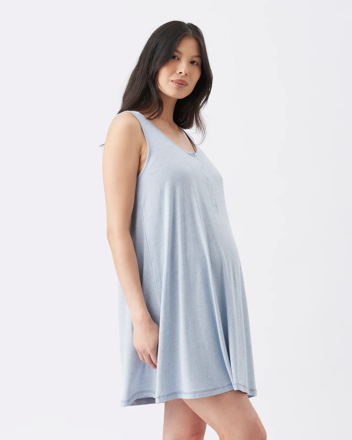 A woman modeling a sleeveless, V-neck babydoll nightgown in a light periwinkle blue color against a plain white studio background.
