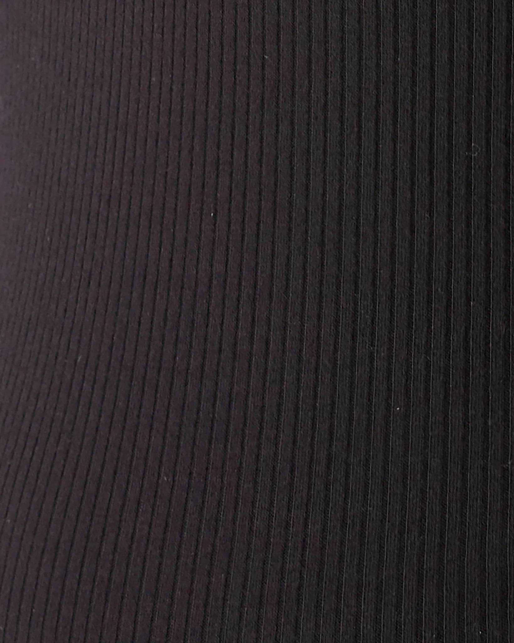 Close-up of a dark ribbed fabric texture with vertical channels, showing a very dark brown or near-black color.