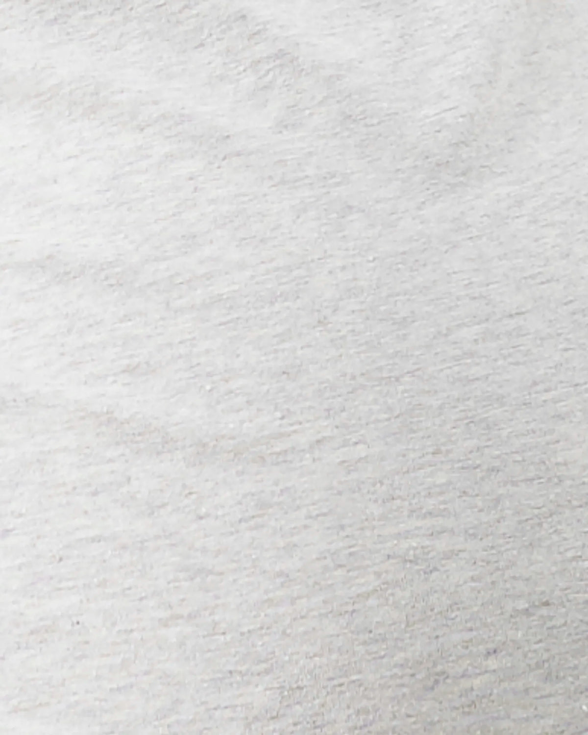 A close-up texture shot of a light gray heathered fabric, showing the fine knit or woven fibers and soft folds.