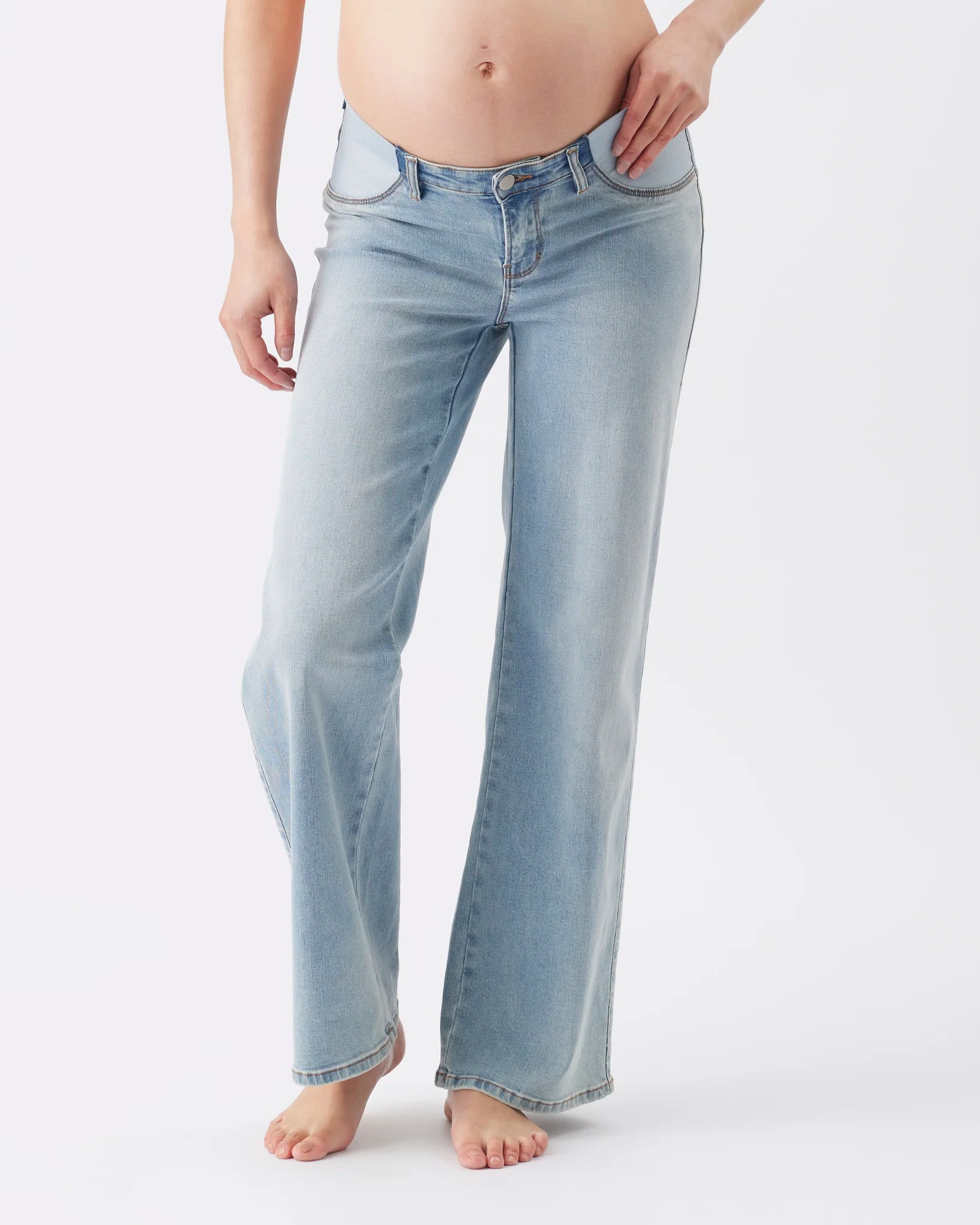A model wearing light-wash blue flare jeans, shown from the waist down against a plain white studio background.