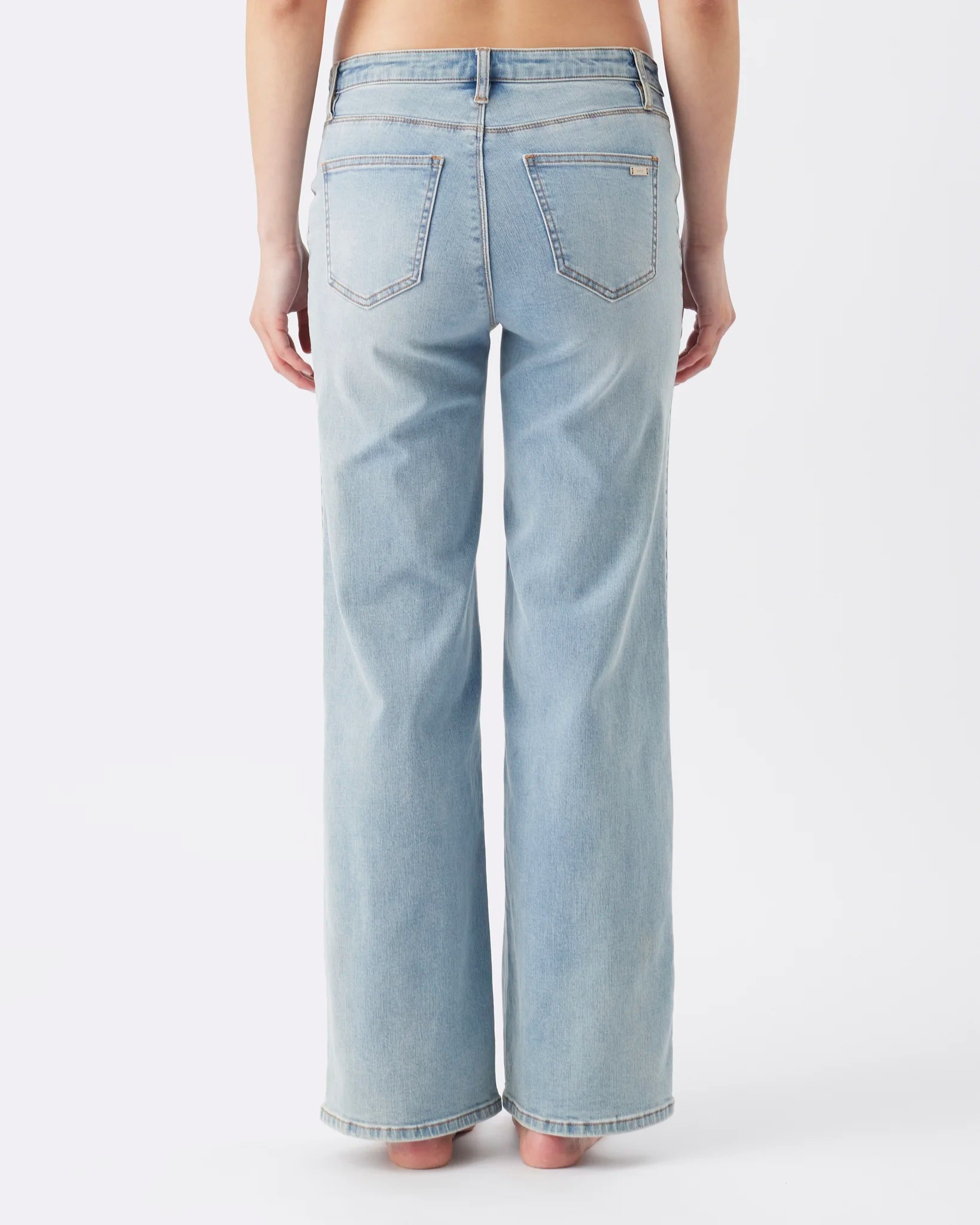 Rear view of a person wearing light-wash blue wide-leg jeans against a plain white studio background.