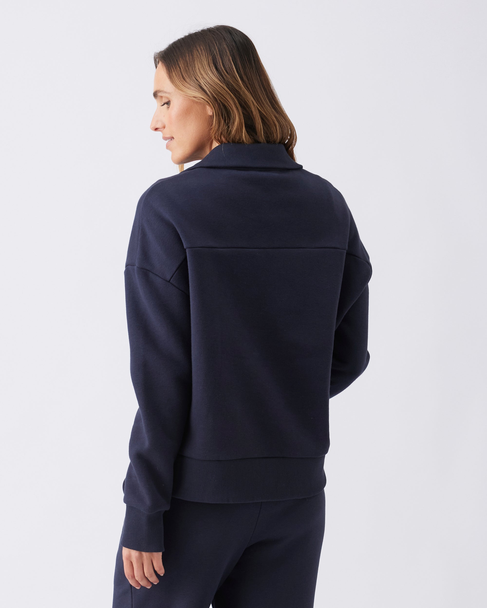 Back view of a woman wearing a navy blue winter weight sweater top.